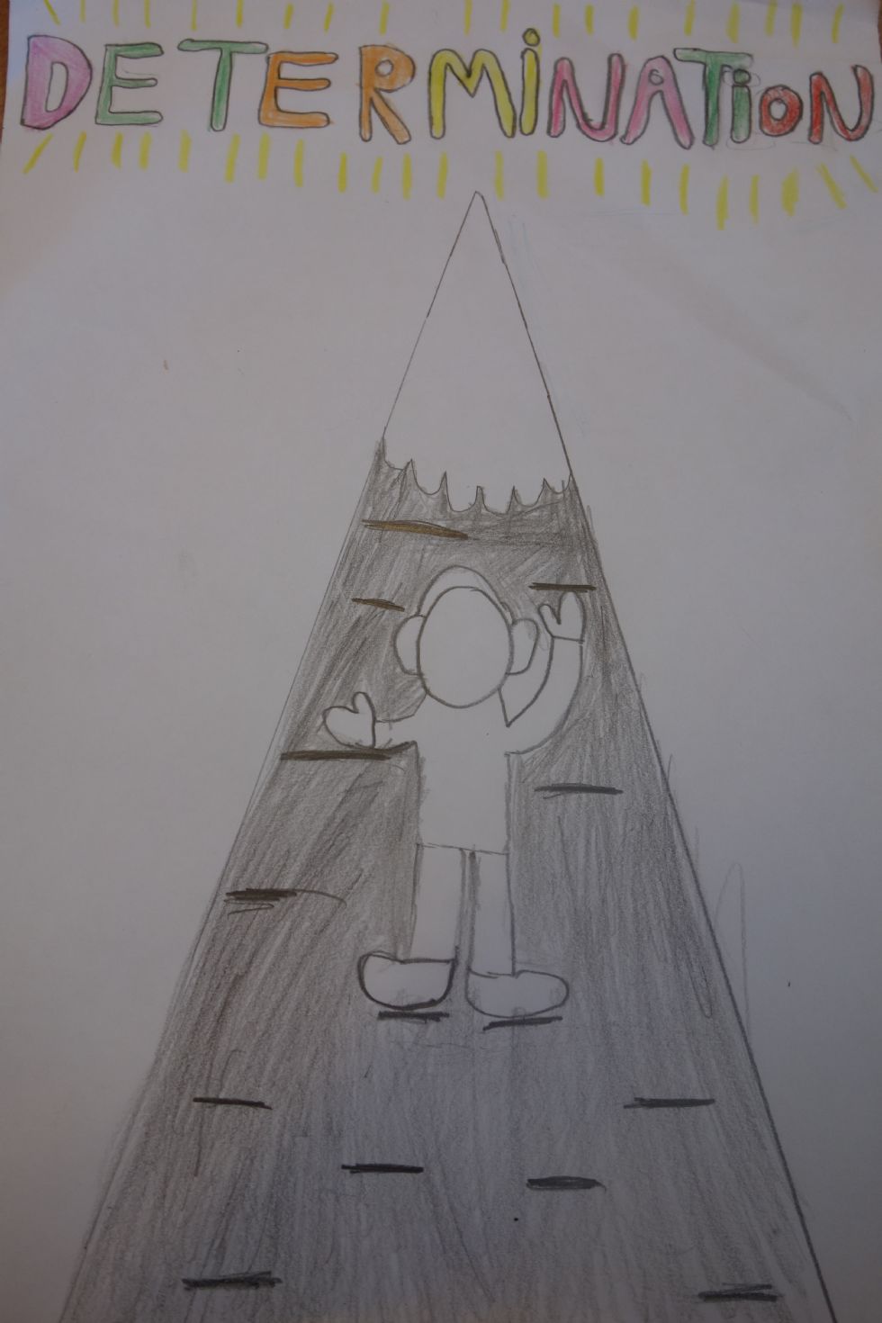 A child's drawing of someone climbing a mountain with the word determination written above it