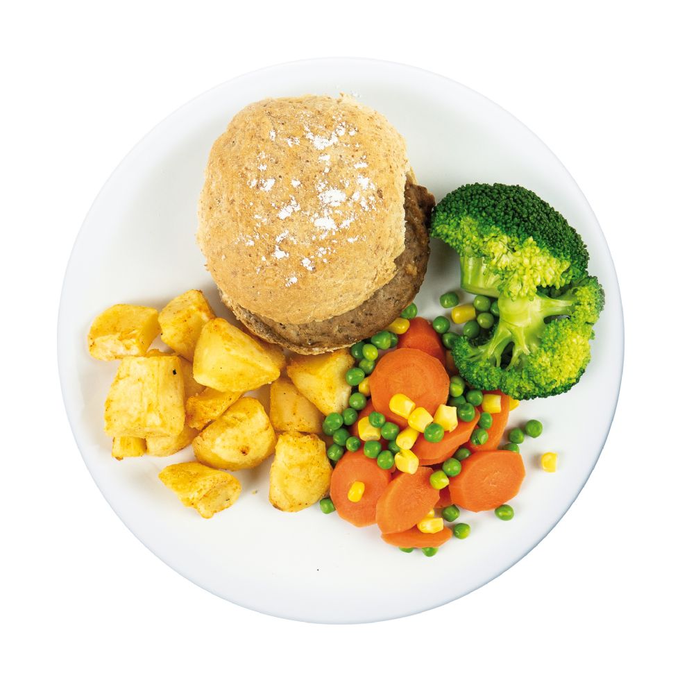 Beef burger in a bun with potatoes and vegetables